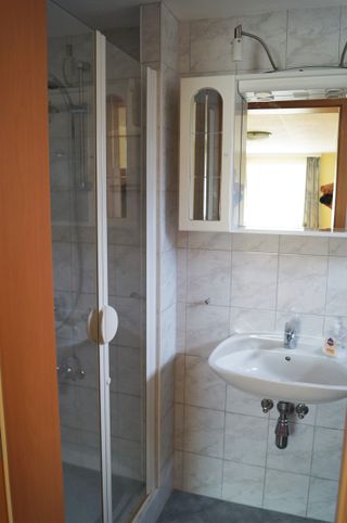 Duschraum mit Waschbecken und WC