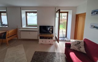 Wohnzimmer mit Samsung 43-Zoll-TV und Blick auf die Gartenterrasse.