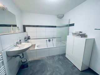 Großes, helles Badezimmer mit Fußbodenheizung