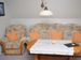 Wohnzimmer mit Küchenzeile FlachbildTV und Couchgarnitur zum gemütlichen Sitzen