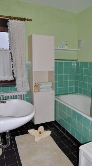 Badezimmer mit Wanne und Duschabtrennung