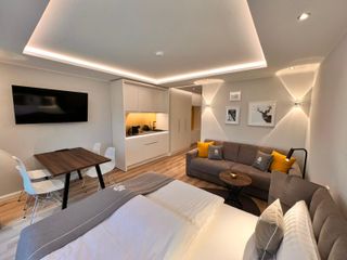 Blick in das Apartment mit Sofa, Sitzecke und Küchenzeile im Hintergrund