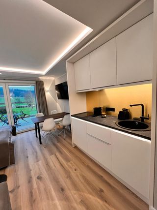 Blick auf die Küchenzeile mit Esstisch und Fernseher im Hintergrund
