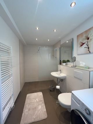 Badezimmer mit großer Dusche und Handtuchtrockner