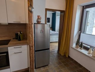 freistehender Kühlschrank und Blick ins Schlafzimmer