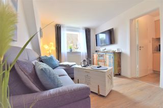 Wohnzimmer mit großer Couch und Fernseher