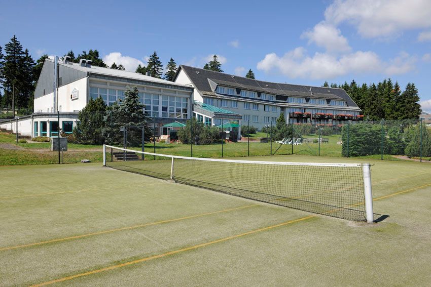Außenansicht Hotel mit Tennisplatz