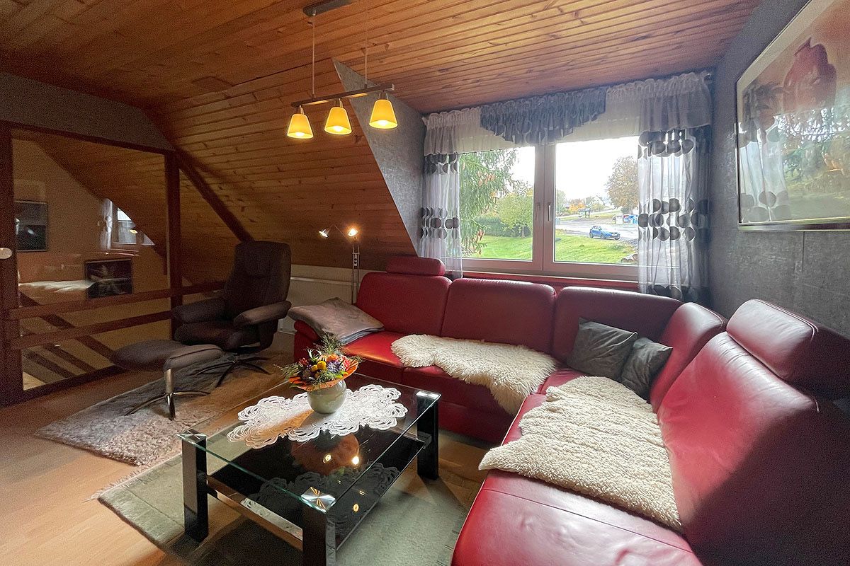 Wohnzimmer mit Fernseher und Couch mit Schlaffunktion