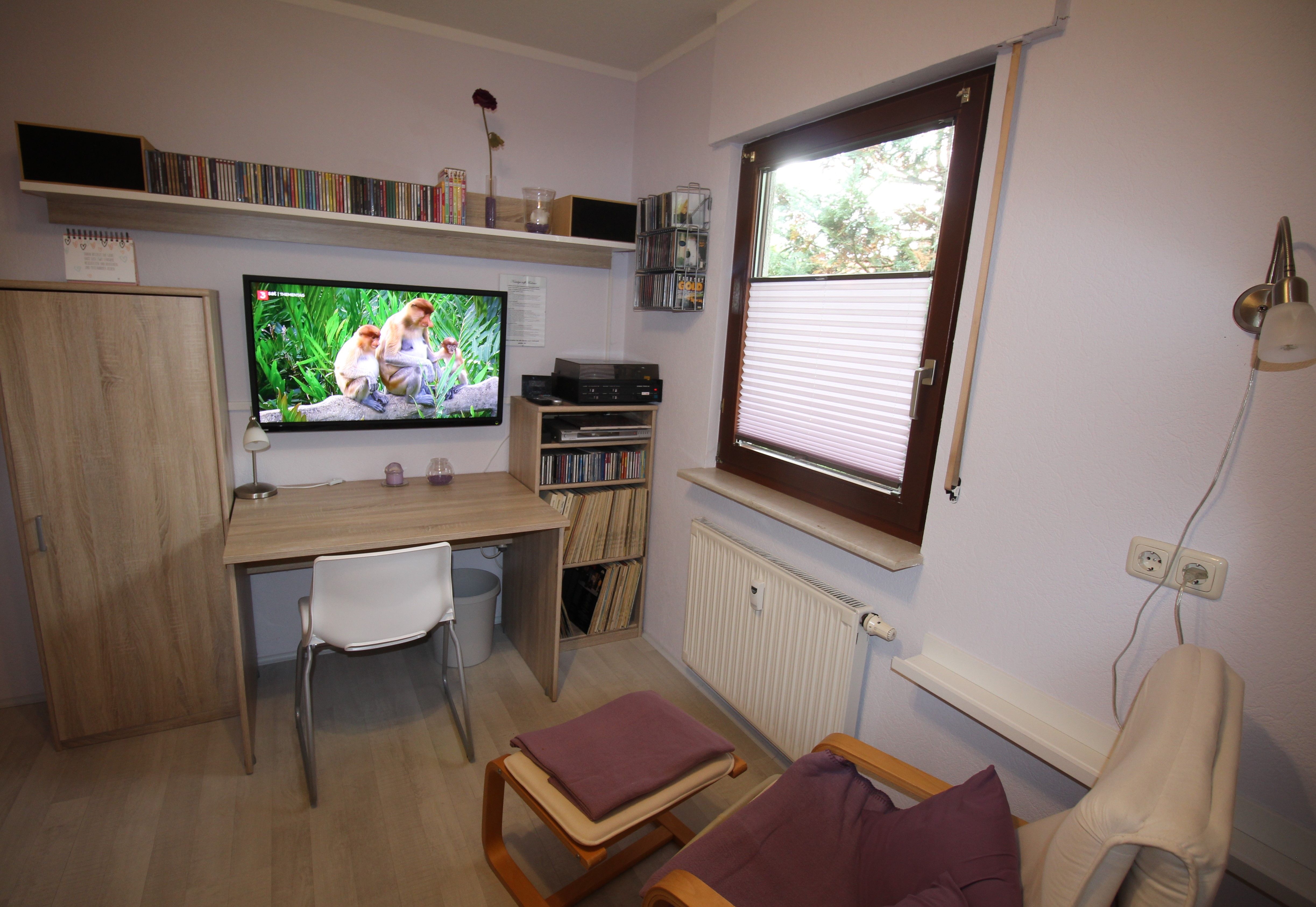 Schlafzimmer mit Relaxsessel und TV