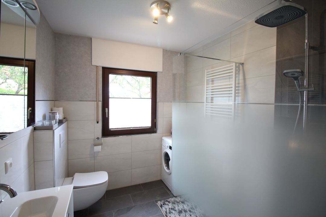 Badezimmer mit Regendusche und Waschmaschine