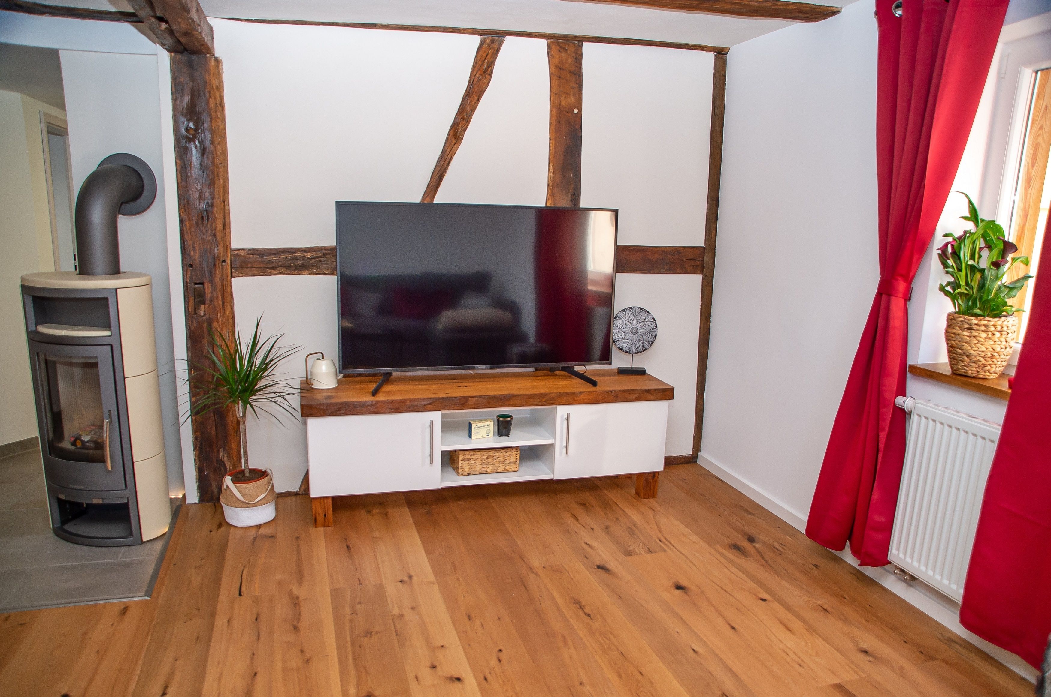 Wohnzimmer mit Kaminofen und Smart TV