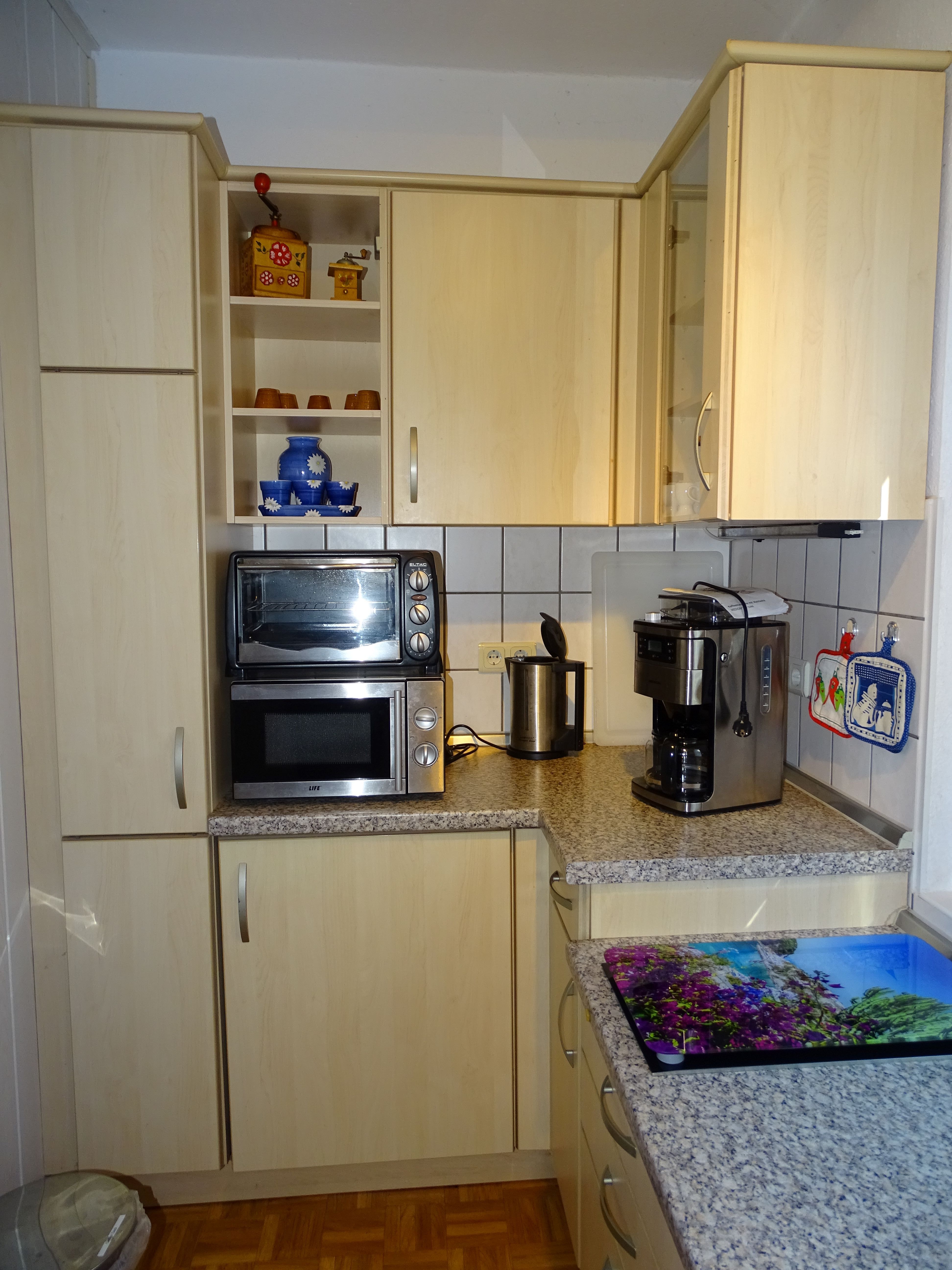 Küche mit Microwelle, Kaffeemaschine mit Mahlwerk, kleiner Backofen und Herd